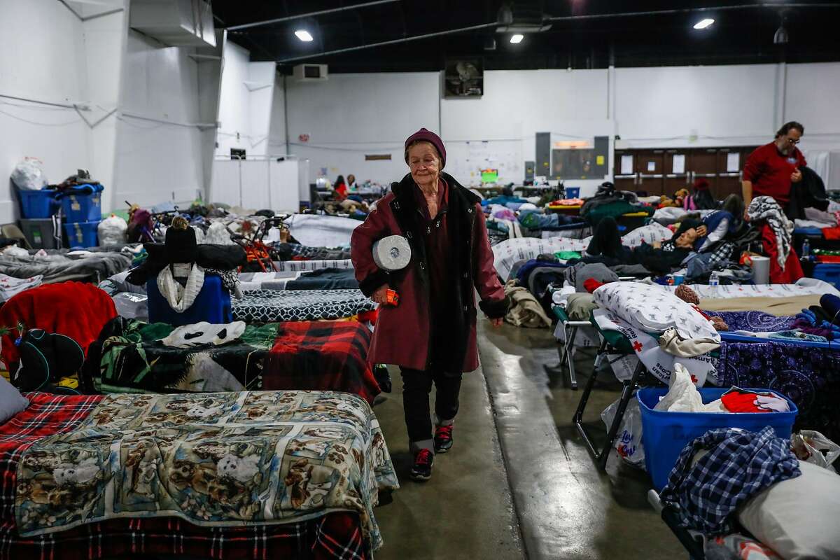 Jerillyn Ramsey, 72 (right) walks through the Red Cross Shelter at the Silver Dollar Fairgrounds five-weeks after the Camp Fire decimated the town of Paradise in Chico, California, on Wednesday, Dec. 19, 2018.