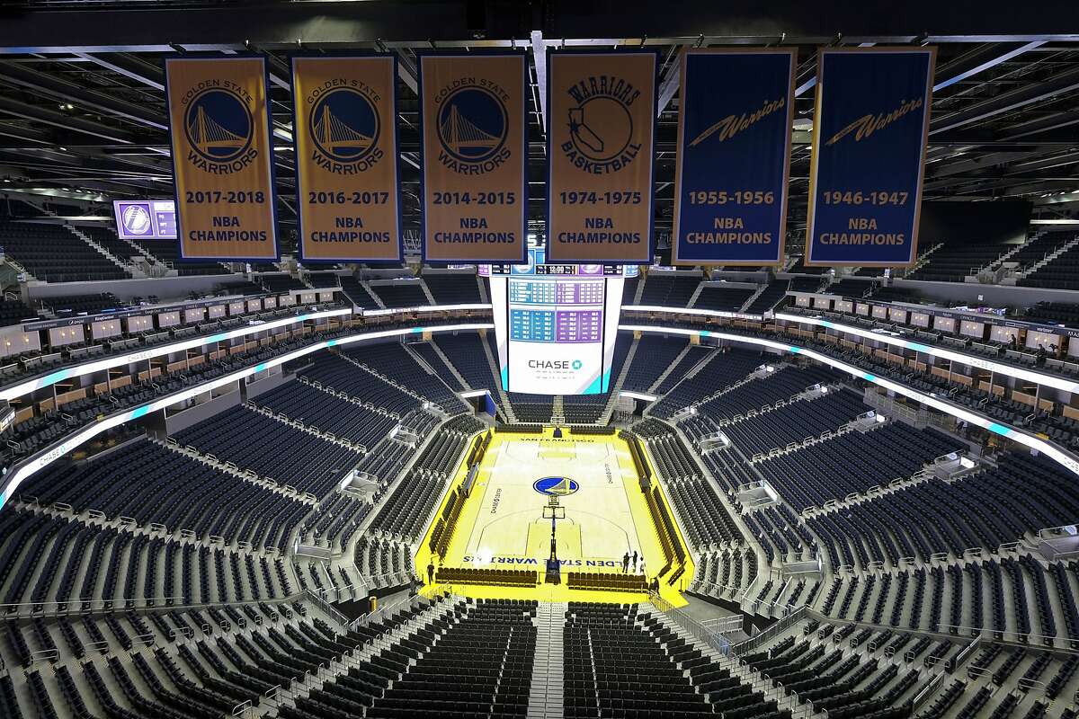 FILE - In this Aug. 26, 2019, file photo, the Golden State Warriors championship banners hang above the seating and basketball court at the Chase Center in San Francisco. The Warriors will play the Brooklyn Nets at home Thursday night, March 12, 2020, in the first NBA game without fans since the outbreak of the coronavirus. (AP Photo/Eric Risberg, File)
