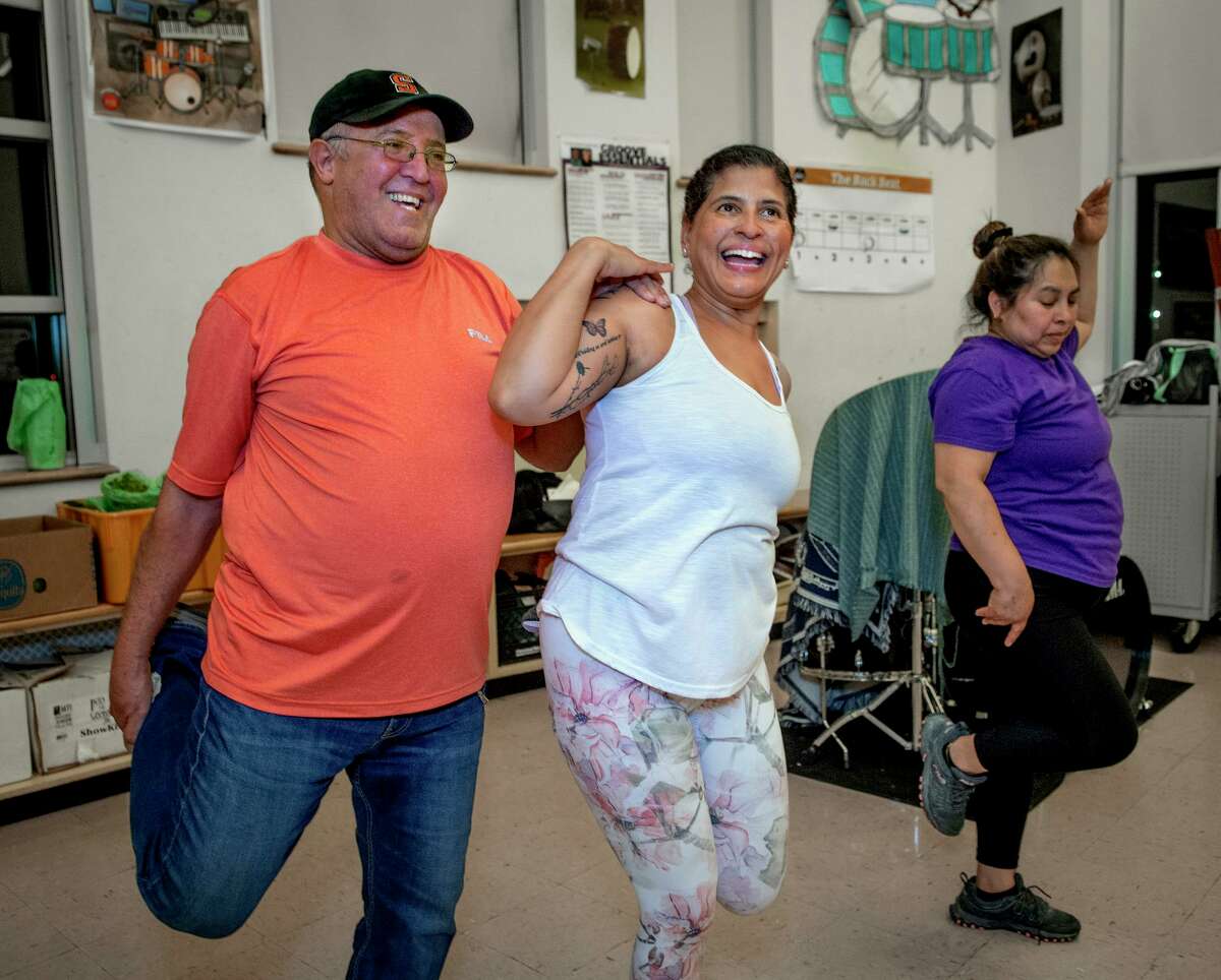 Juan Ortiz, left, gets some help from exercise instructor, Amanda Mia, center, during an exercise and nutrition class at John S Martinez School in New Haven. At right is Soyla Aguilar.