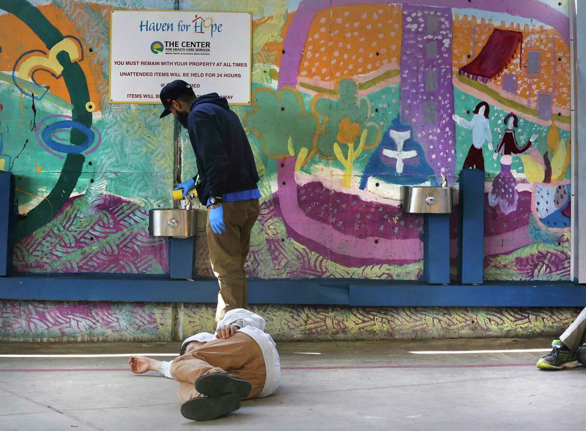 Haven for Hope assists people who are homeless and those at risk for homelessness. In this March, 2020 photo, staff member Ira Nieto cleans water fountains in the shelter’s courtyard