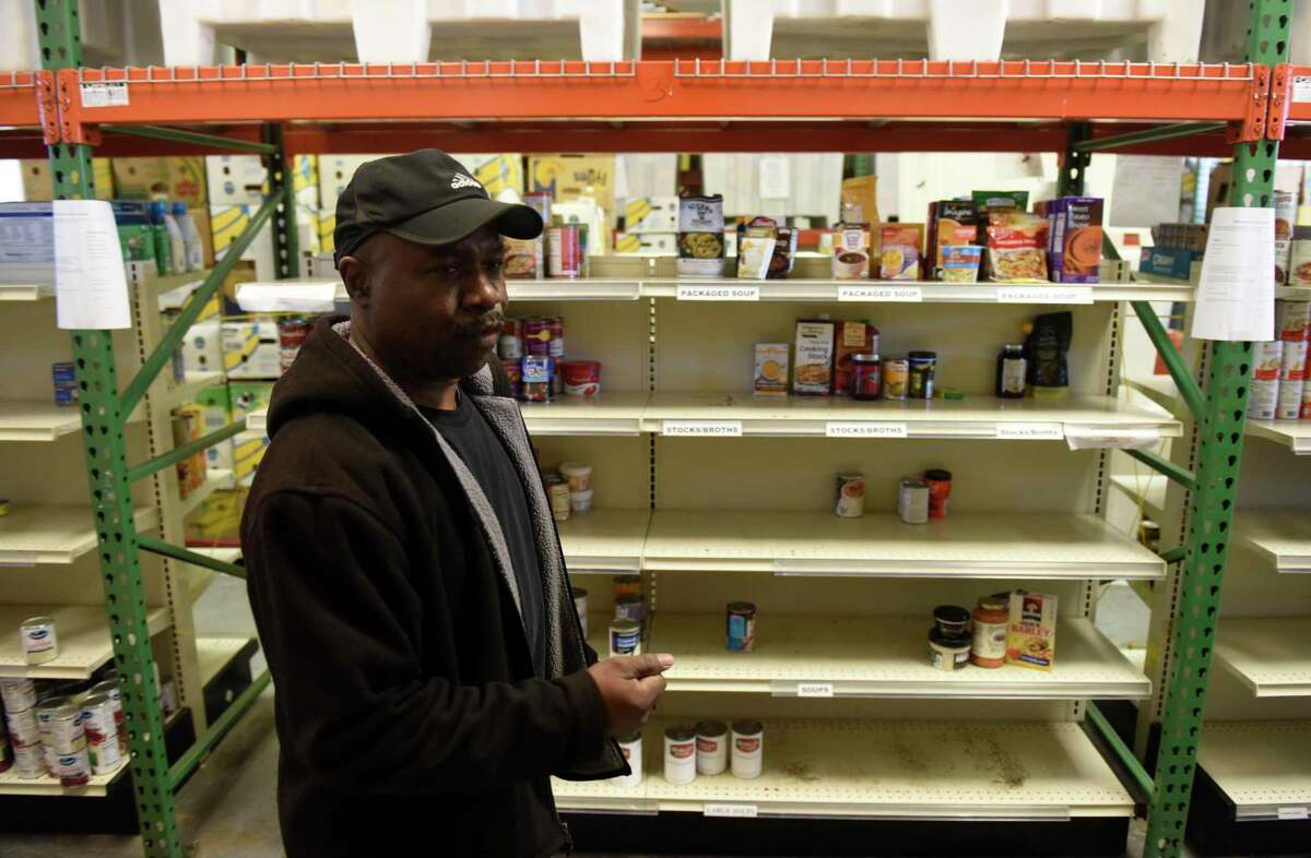 Warehouse Manager Willie Johnson chats beside a row of empty shelves at the Food Bank of Lower Farifield County in Stamford, Conn. Monday, March 9, 2020. Since the coronavirus outbreak, the food bank has experienced a shortage of food, particularly pasta, cereal and nonperishable canned goods.