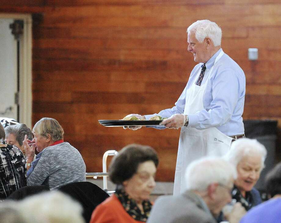Greenwich Selectman John Toner serves a meal during the Greenwich Senior Center's annual Thanksgiving lunch party at the Eastern Greenwich Civic Center, Old Greenwich, Conn., Friday, Nov. 17, 2017. A traditional roasted turkey dinner was served by volunteers and Greenwich community leaders. Photo: Bob Luckey Jr. / Hearst Connecticut Media / Greenwich Time