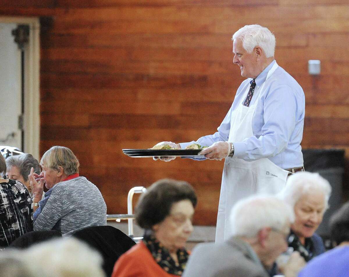 Greenwich Selectman John Toner serves a meal during the Greenwich Senior Center's annual Thanksgiving lunch party at the Eastern Greenwich Civic Center, Old Greenwich, Conn., Friday, Nov. 17, 2017. A traditional roasted turkey dinner was served by volunteers and Greenwich community leaders.