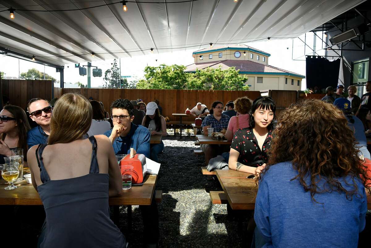 People sit under the retractable roof at Arthur Mac's Tap and Snack beer garden in Oakland, CA, on Saturday June 24, 2017.