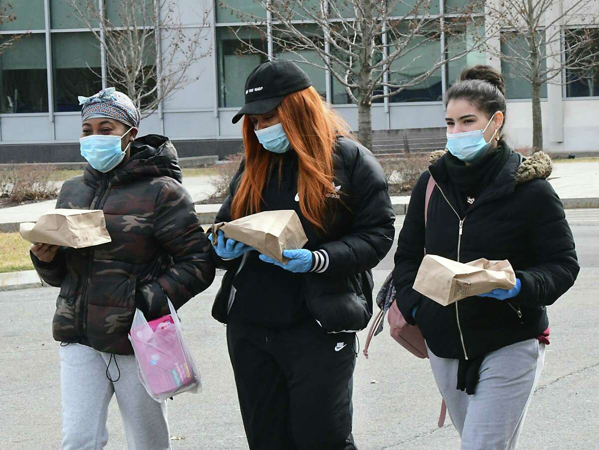 From left, University at Albany juniors Sophia Taylor of the Bronx, Nyasha Biggs of Brooklyn, and Sharinel Nunez of Brooklyn walk back to their dorm from the Campus Center with pizza at UAlbany on Thursday, March 12, 2020 in Albany, N.Y. Some students were wearing face masks due to the coronavirus cases. (Lori Van Buren/Times Union)