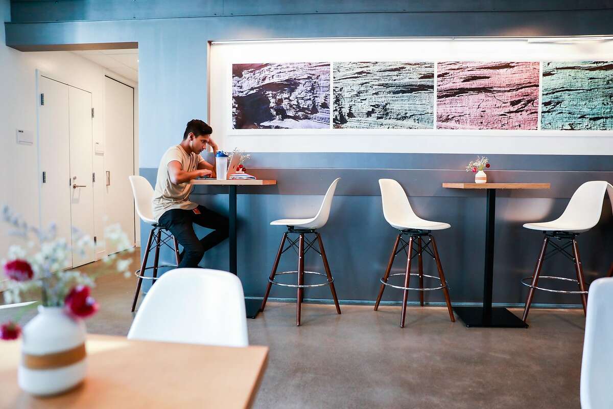 Imesh Samarakoon works at Andytown coffee in a largely empty space in SOMA on Wednesday, March 11, 2020 in San Francisco, California. The coffee shop would normally be packed during the day. The coronavirus has impacted many businesses because people have been told to work from home.