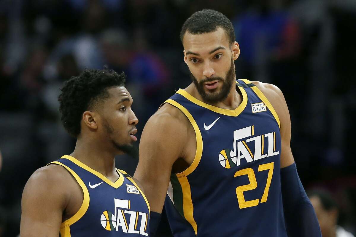 Utah Jazz center Rudy Gobert (27) talks with guard Donovan Mitchell, left, during the second half of an NBA basketball game against the Detroit Pistons Saturday, March 7, 2020, in Detroit. (AP Photo/Duane Burleson)