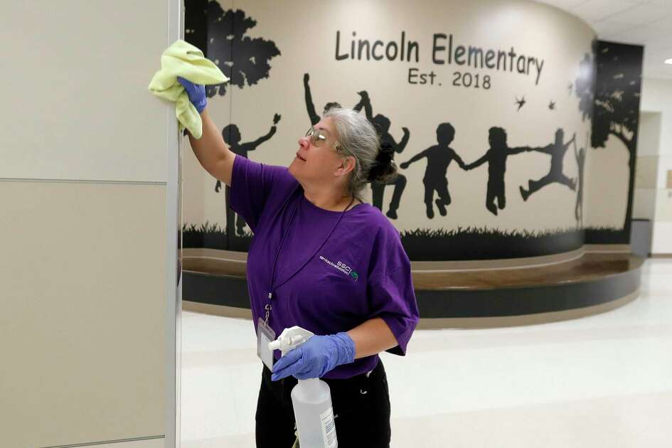 Custodian Ranae Cox works to clear Lincoln Elementary School, Thursday, March 12, 2020, in Montgomery. Members of Montgomery ISD's service for education management began additional disinfectant steps at all of the district's 10 schools. Superintendent Beau Rees announced the district would close two days ahead of spring break in an abundance of caution after health officials announced Montgomery County's first 'presumptive positive' case of the coronavirus on March 11.