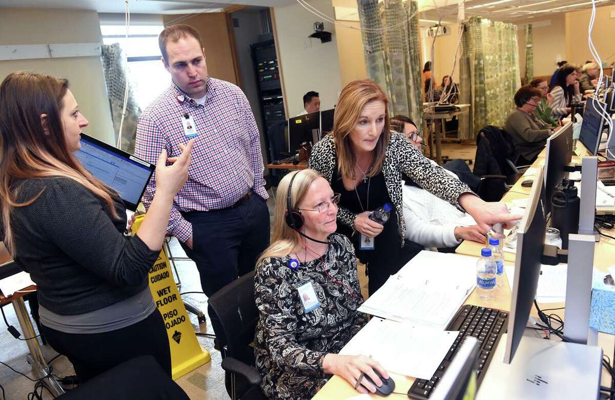 From left, Samantha Fonda, Joshua Williston, Betsy Hine and Stacey Lane collaborate with calls at the Covid-19 Call Center at Yale New Haven Health in Yale New Haven Hospital.