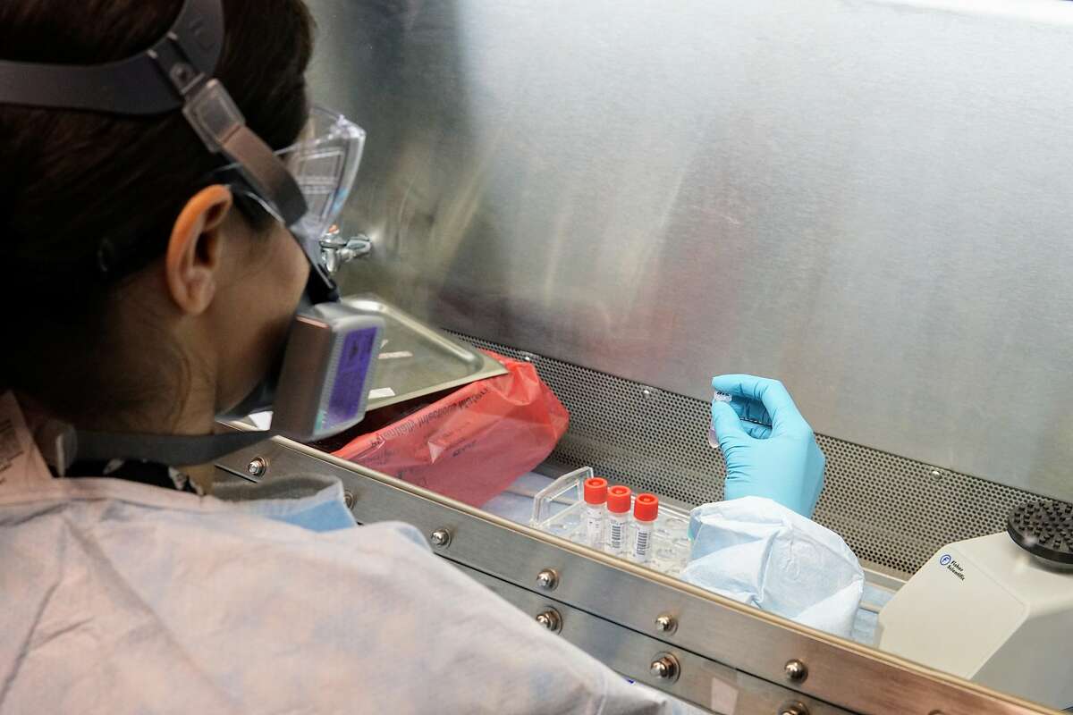 A San Francisco Department of Public Health technician administers a test to see if the sample from a coronavirus test proves positive for the presence of COVID-19.