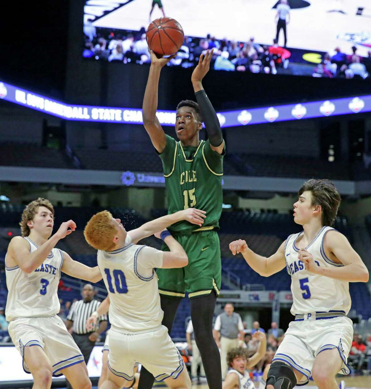 Vince Iwuchukwu gets off a jumper in a crowd during the class 3A state semifinal boys basketball game between Cole and Peaster at the Alamodome on Feb. 12, 2020.