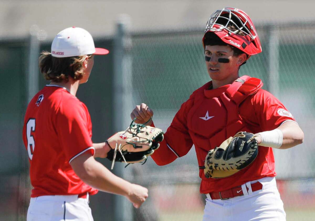 The Woodlands catcher Drew Romo (8) gives relief pitcher Cody Howard a high-five during a non-district high school baseball game at Kingwood Park High School, Thursday, Feb. 27, 2020, in Kingwood. The Woodlands defeated Kingwood Park 10-0.