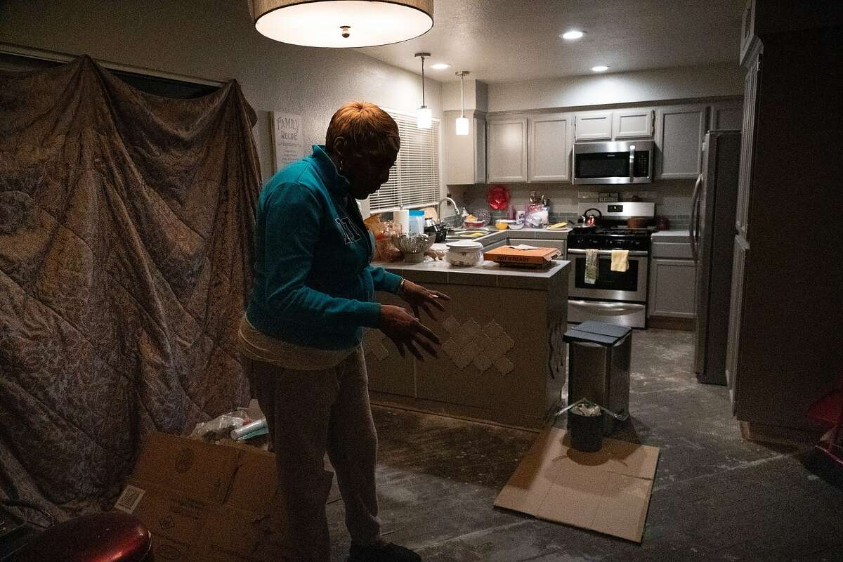 Sylvia Lewis works during the events at Chase and other venues and will lose all her income. She stands in her home, under renovation, where she will be installing a new floor on Thursday, March 12, 2020, in Antioch, Calif.