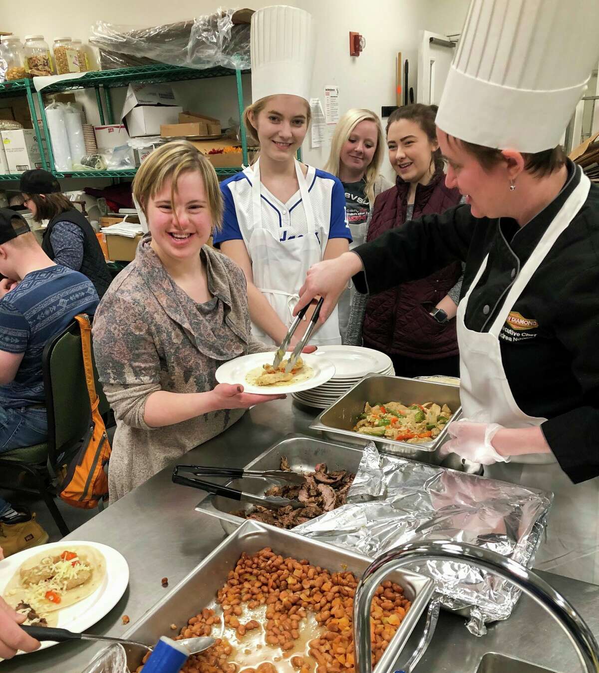A local cooking club whose members who have varying intellectual and developmental disabilities cook a meal together from scratch with guidance from the kitchen staff at Dow Diamond. (Photo provided/Brad Tammen)
