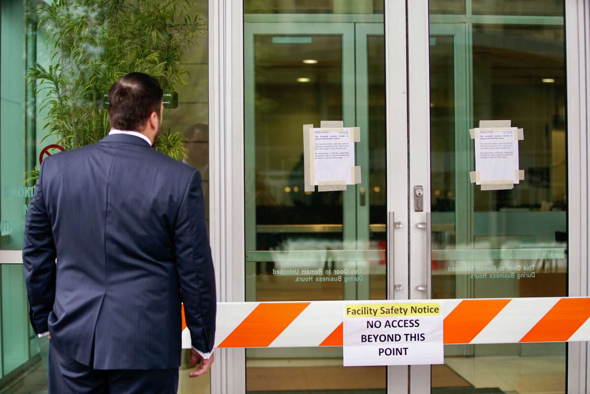 The doors are blocked and signs are up on the doors of the Harris County Juvenile Justice Center Friday, March 13, 2020, in downtown Houston.