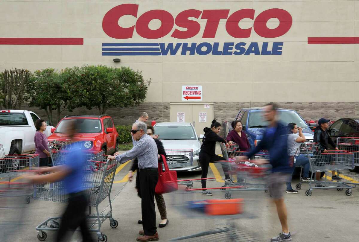 People wait in line for the Costco Wholesale at Bunker Hill Road to open Friday, March 13, 2020, in Houston. People are rushing to grocery stores amid fears of the new coronavirus pandemic.