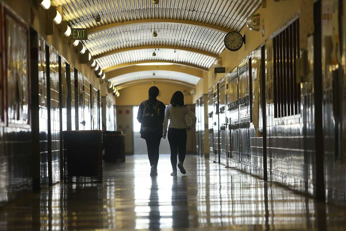 Two students walk through a corridor at Thurgood Marshall Academic High School on Thursday, March 12, 2020 in San Francisco, Calif.
