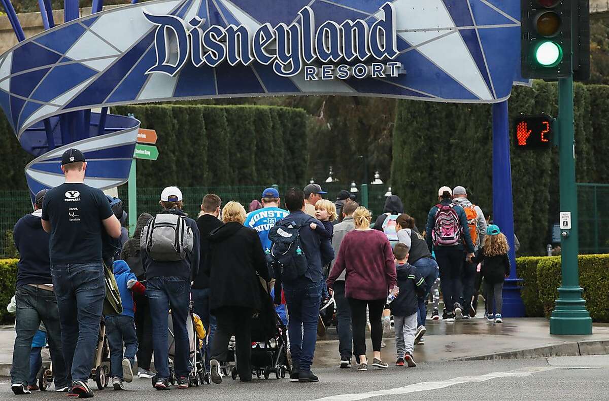 ANAHEIM, CALIFORNIA - MARCH 13: Disneyland visitors enter the famed amusement park on March 13, 2020, in Anaheim, California. Walt Disney Co. is shuttering Disneyland Park and Disney California Adventure tomorrow until the end of the month due to the spread of COVID-19. (Photo by Mario Tama/Getty Images)