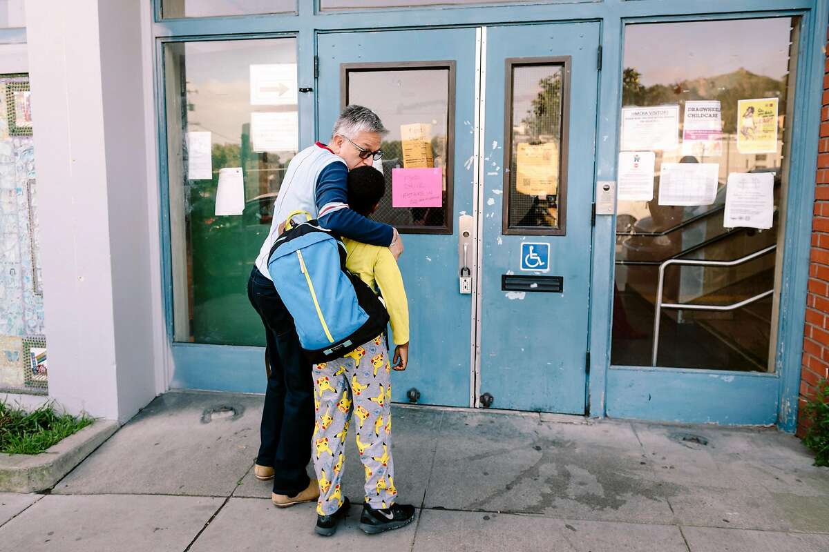 Willie Ramirez gives his son Akeem Ramirez, 8 years old, a kiss goodbye during morning drop-off at Harvey Milk Civil Rights Academy in San Francisco, California, US, on Friday, March 13, 2020.