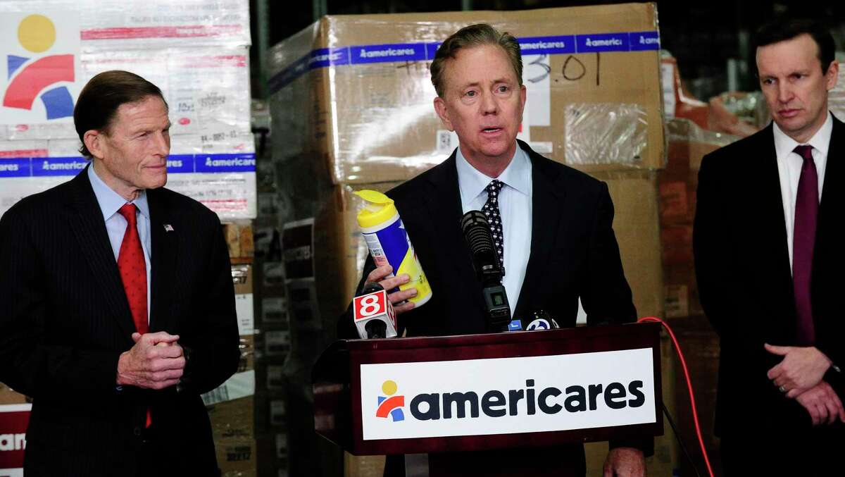 Governor Ned Lamont and U.S. Senators Richard Blumenthal and Christopher Murphy visit Americares' headquarters and global distribution center to receive an update on the health-focused relief and development organization's response to the COVID-19 pandemic on March 13, 2020 in Stamford, Connecticut. The governor holds a container of cleaning wipes as he speaks with the media.