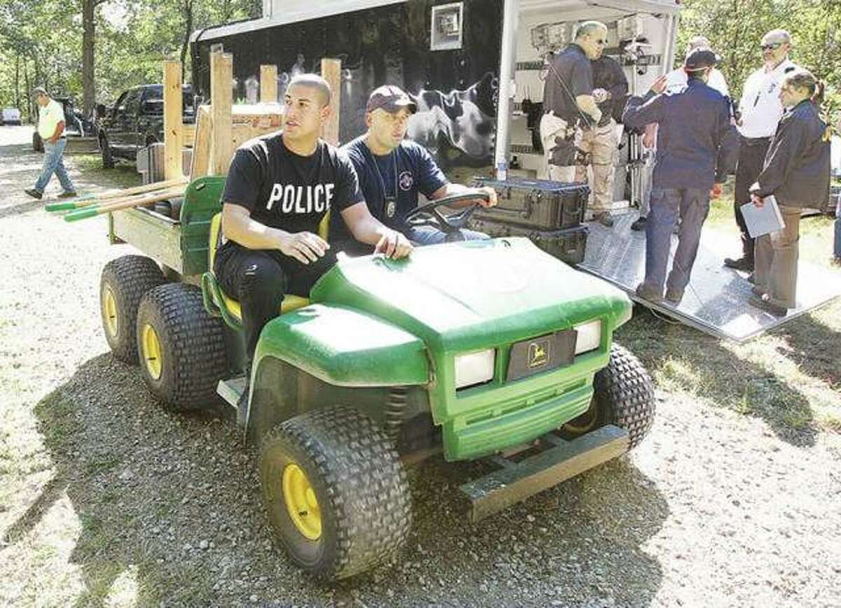 In this September 2010 file photo, Alton Police officers Marcos Pulido, left, now deputy chief, and Seth Stinnett, right, now chief of detectives, head off on an off-road vehicle to search the rural Jerseyville property of Roger Carroll.