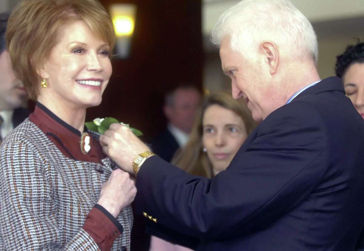 Mary Tyler Moore arrives at the Hyatt Regency Greenwich, to speak at the Junior League's 50th anniversary luncheon in April 2009. Terry Sims, Moore's assistant, pins a corsage on her.