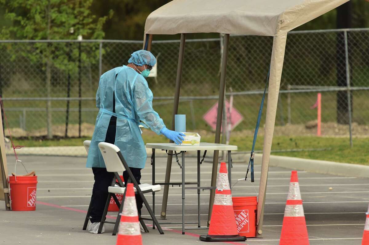A medical technician prepares for the arrival of people who have orders to be tested for the novel coronavirus at the new drive-through testing facility at the Texas Medical Center on Saturday, March 14, 2020. Doing the testing outside makes it less likely that the virus could be spread.