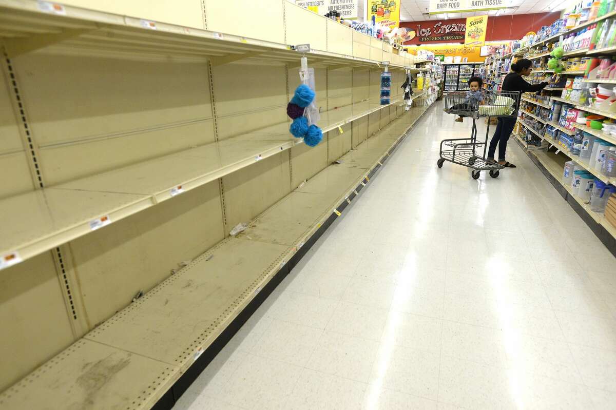 Shoppers stock up amid some barren and near-empty shelves of staples, especially toilet paper, paper towels, water and bread, at the Market Basket on Phelan and Major in Beaumont Friday as residents stock up in preparation for the potential spread of the coronavirus and quarantine conditions. Photo taken Friday, March 13, 2020 Kim Brent/The Enterprise