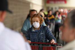 A shopper wears a masking while waiting to enter a Costco in the Bay Area city of Novato.