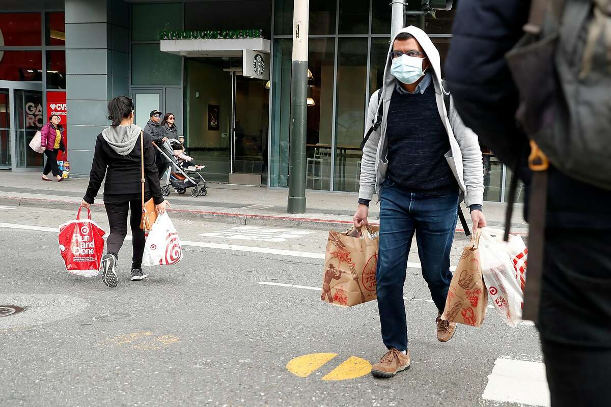 Shoppers cross Mission Street in San Francisco, Calif., on Sunday, March 15, 2020.