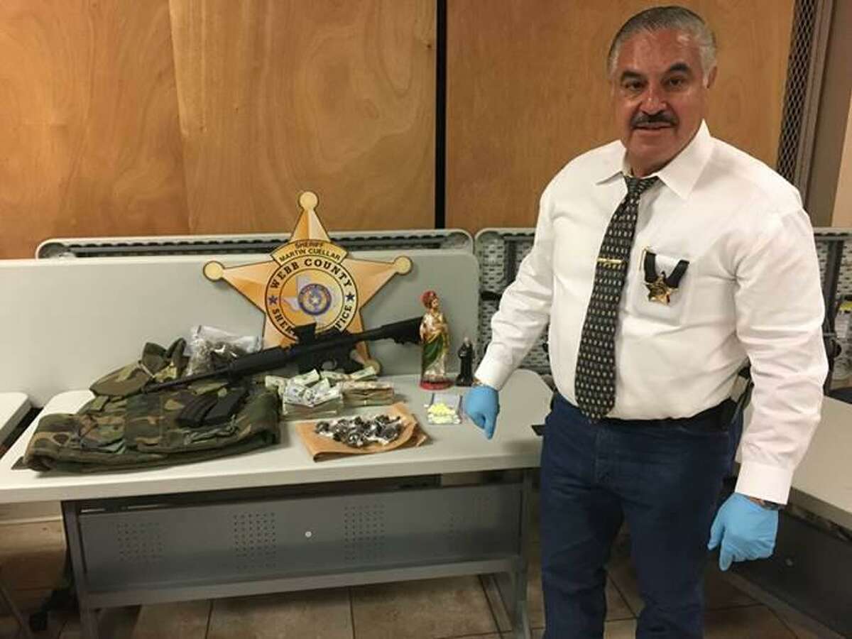 Sheriff Martin Cuellar is shown with the drugs, money and weapons seized during a raid Friday the 2300 block of Jean Street.