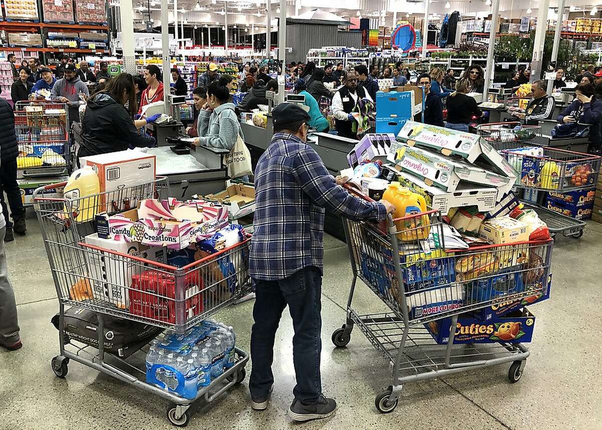 A Costco customer stands by his two shopping carts at a Costco store on March 13, 2020 in Richmond, California. Some Americans are stocking up on food, toilet paper, water and other items after the World Health Organization (WHO) declared Coronavirus (COVID-19) a pandemic.