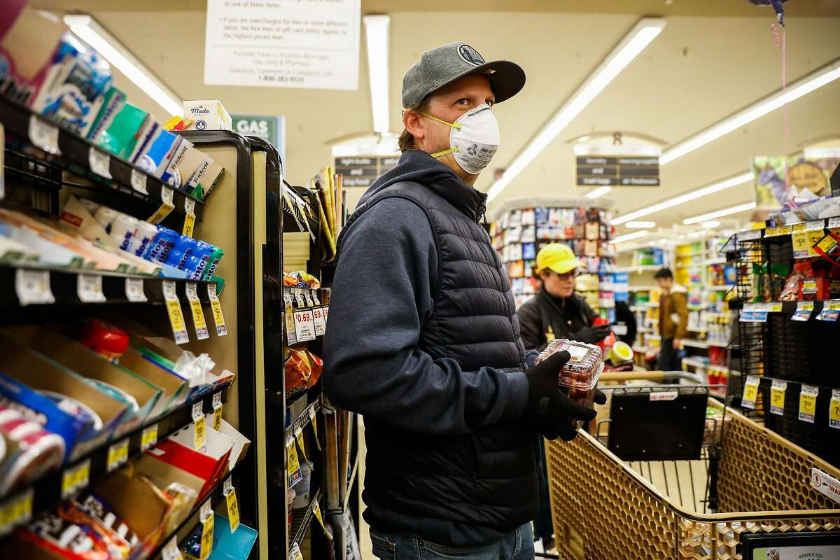 詹姆斯·里德在旧金山西夫韦超市购物时戴着手套和口罩。