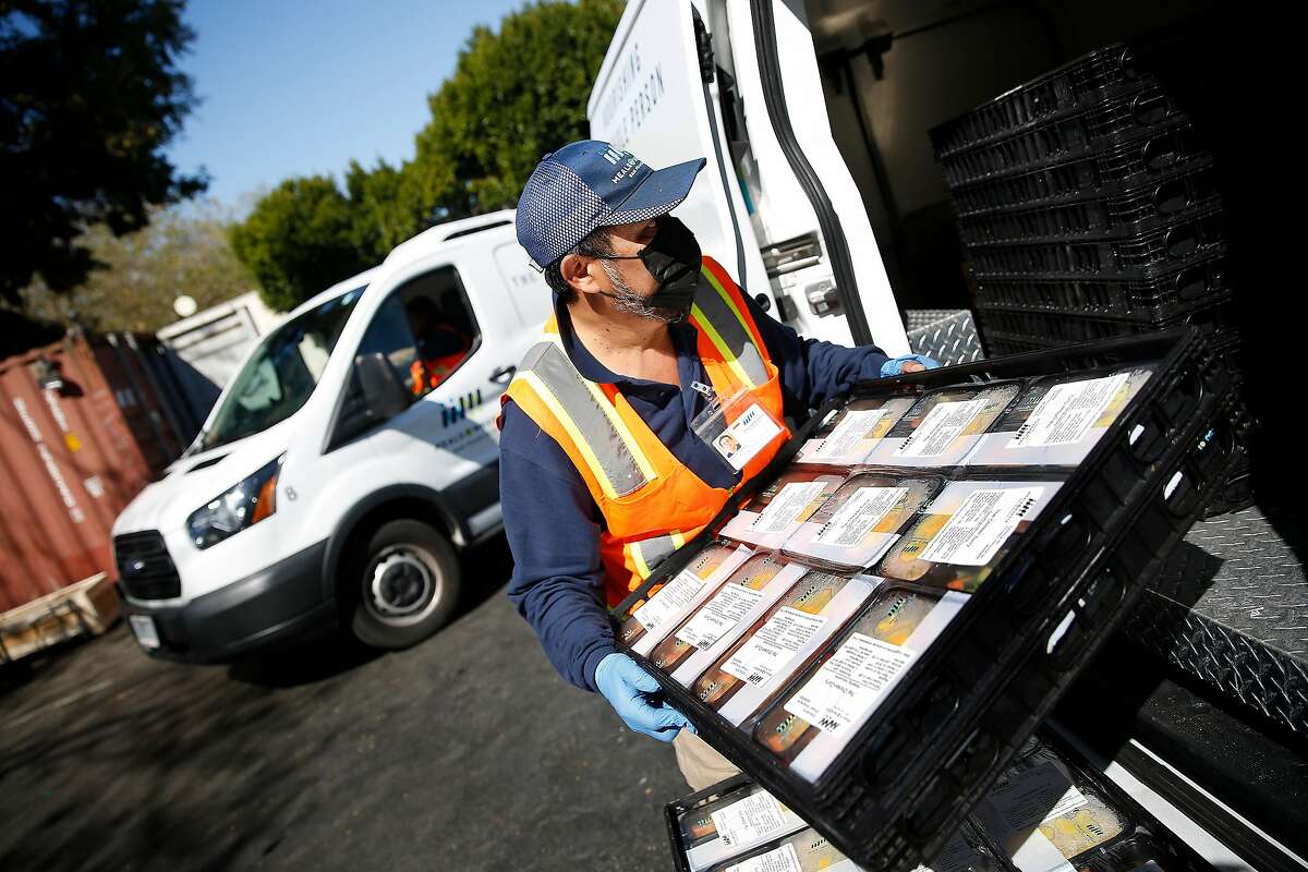 Santos Cetina, Meals on Wheels driver, places meals for delivery into a van at Meals on Wheels on Thursday, March 12, 2020 in San Francisco, Calif.