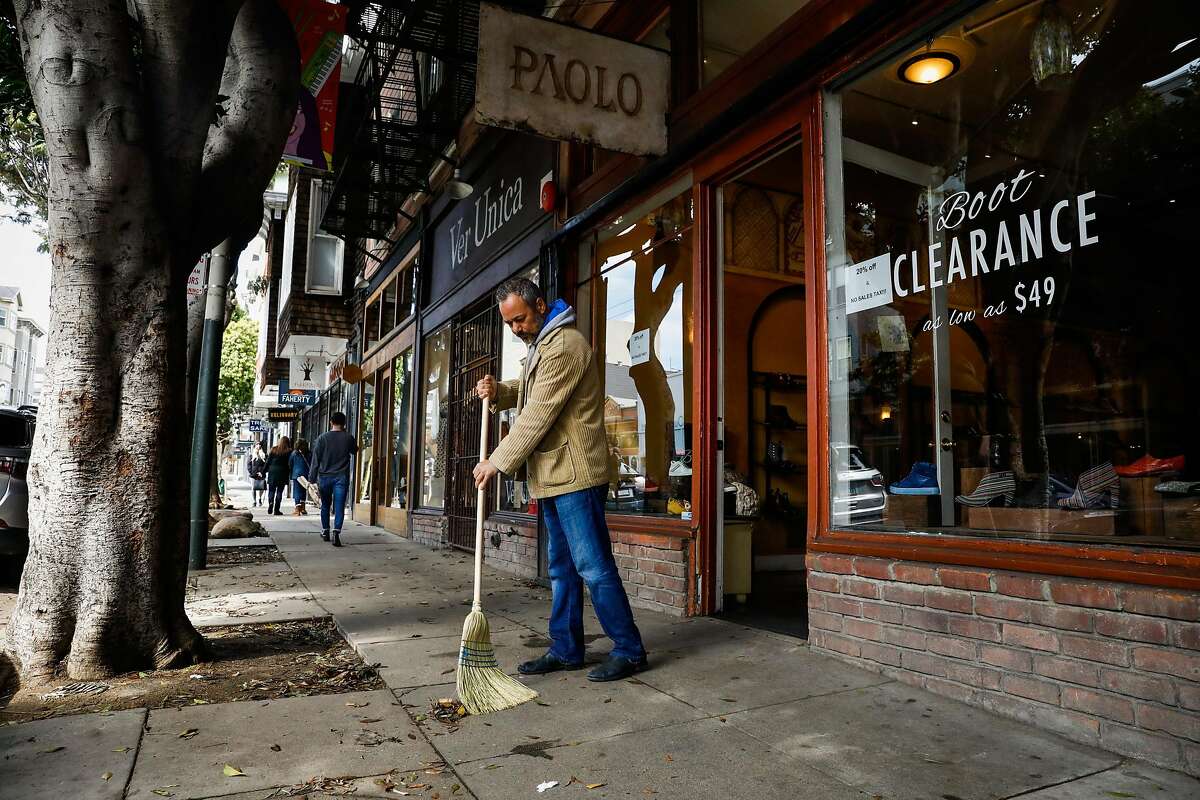 Chaari A., owner of Paolo sweeps outside his shop moments before Mayor London Breed announced that six Bay Area counties would lockdown non-essential services due to the coronavirus on Monday, March 16, 2020 in San Francisco, California