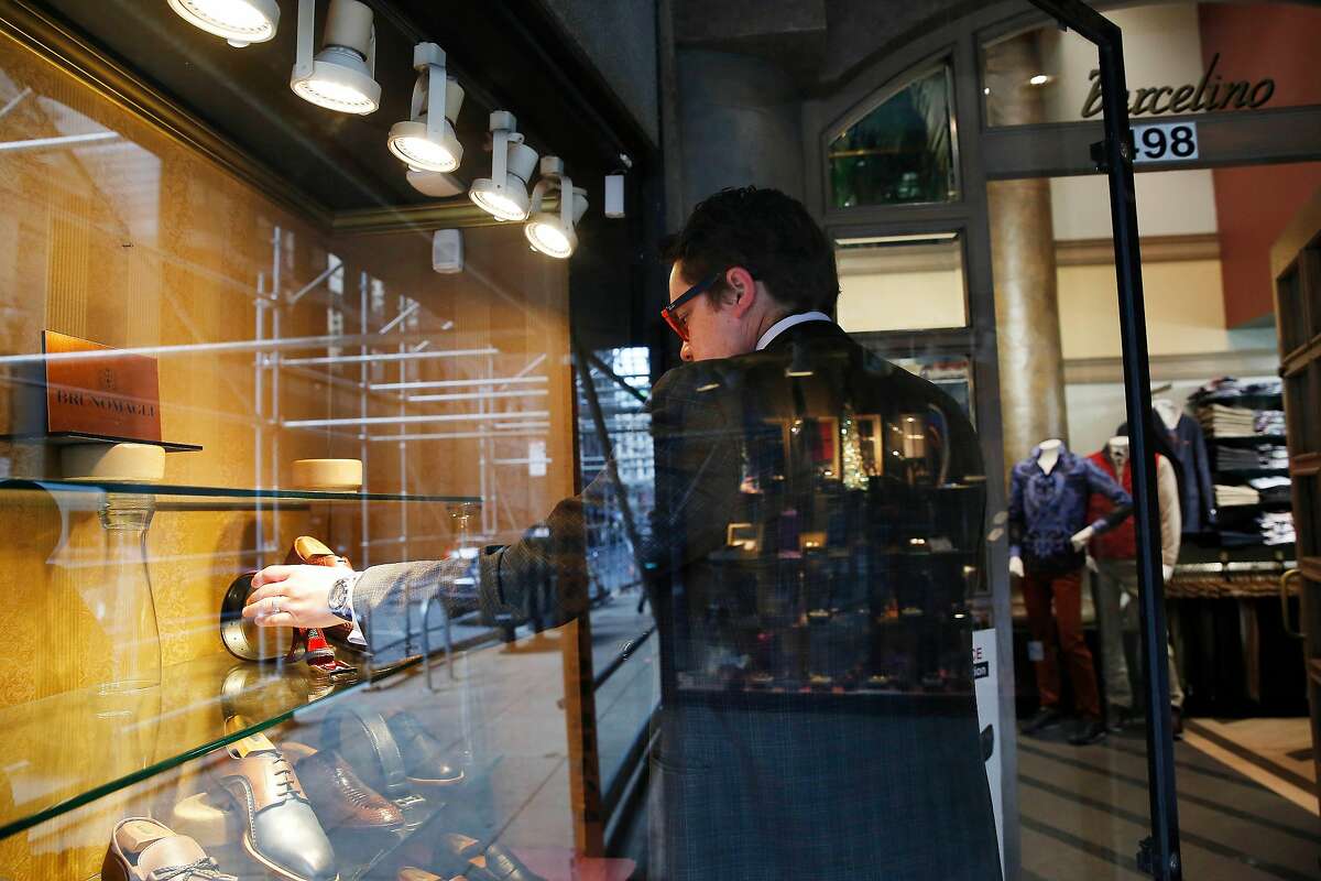 Eric Ramirez, assistant store manager, clears out a display window at Barcelino to prepare for closing the store on Post Street due to San Francisco Mayor London Breed’s announcement of the shelter-in-place order on Monday, March 16, 2020 in San Francisco, Calif.