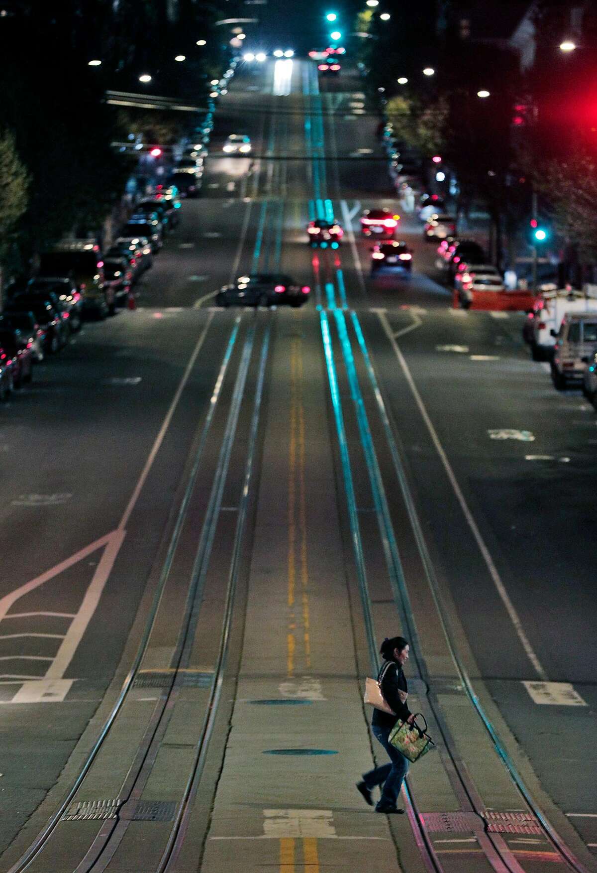 A pedestrian crosses a nearly empty California Street at Polk as the city began to shut down following an order to shelter in place in San Francisco, Calif., on Monday, March 16, 2020. The six Bay Area counties issued a shelter in place order for residents to try and curtail the spread of the Covid-19 virus.