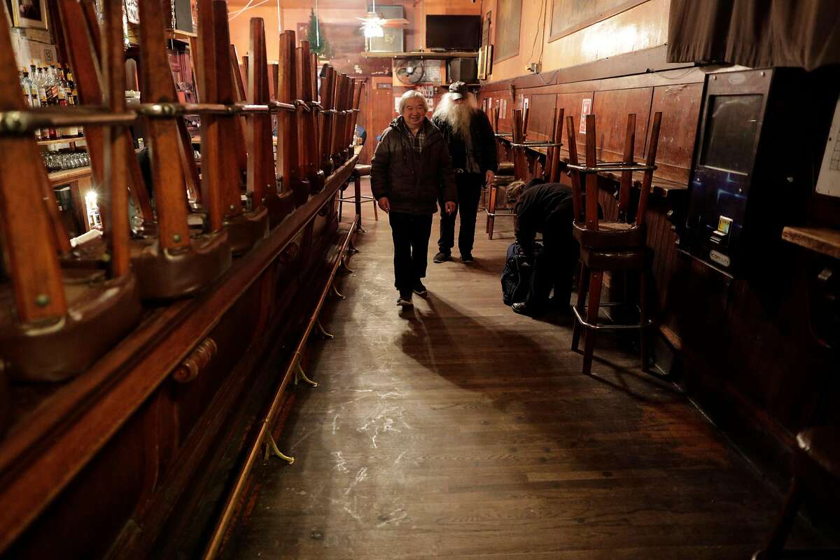 Myron Mu, the owner of The Saloon, walks toward the exit after closing as the city began to shut down following an order to shelter in place in San Francisco, Calif., on Monday, March 16, 2020. The six Bay Area counties issued a shelter in place order for residents to try and curtail the spread of the Covid-19 virus.