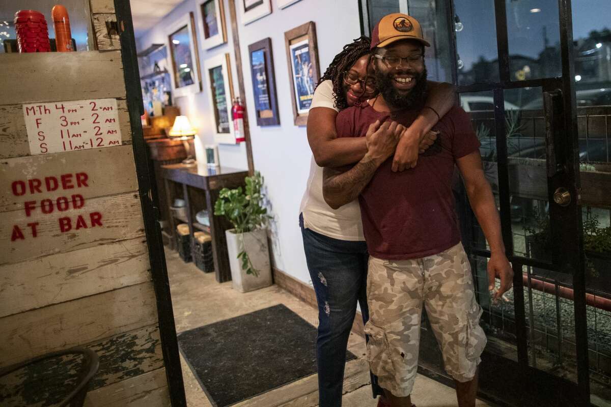 Brigette Nays embraces Rob Huery at Ladybird's Bar on Monday, March 16, 2020, in Houston, the last evening open before the 15 days bar locked down because of COVID-19.