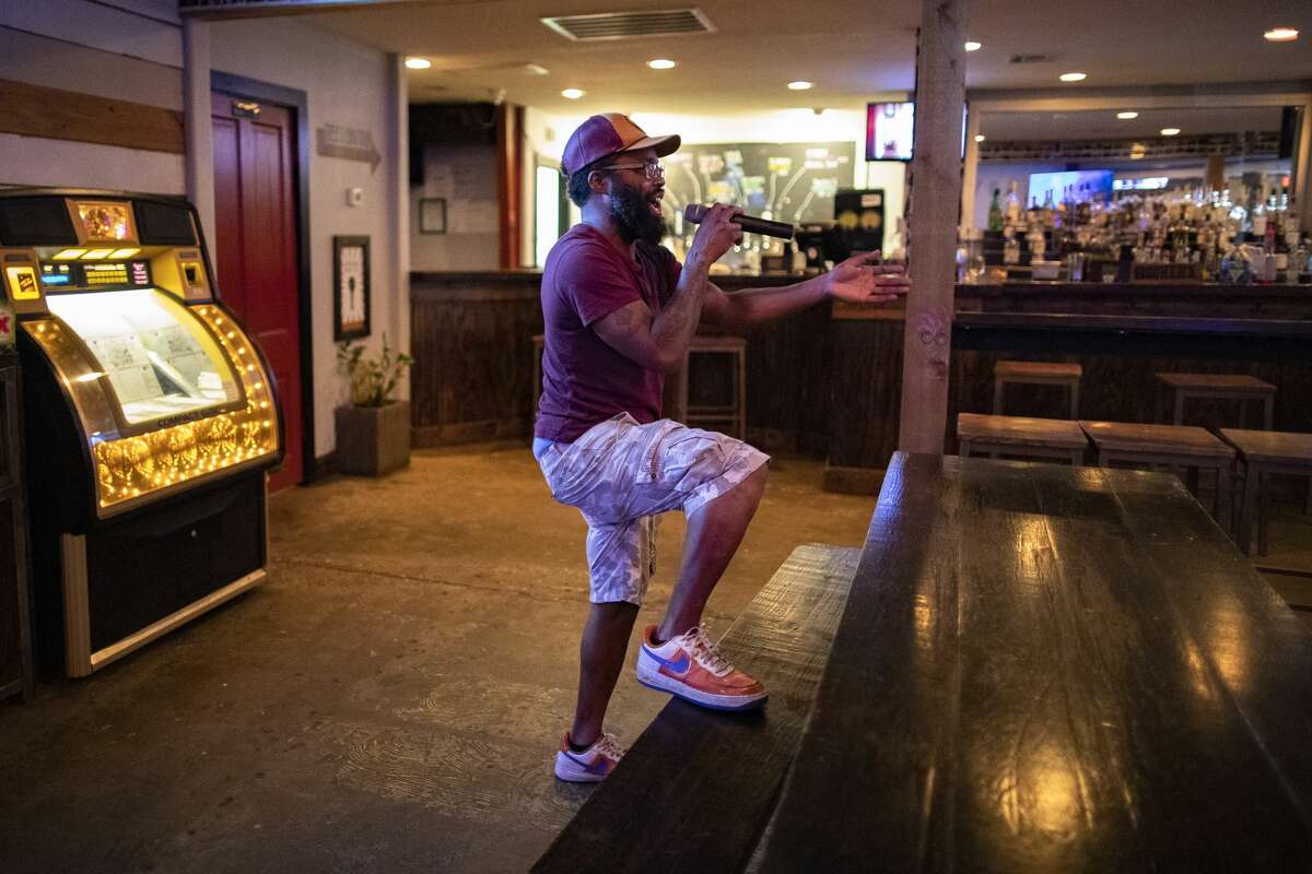 Rob Huery a bartender at Ladybird's Bar sings karaoke during a slow night on Monday, March 16, 2020, in Houston.