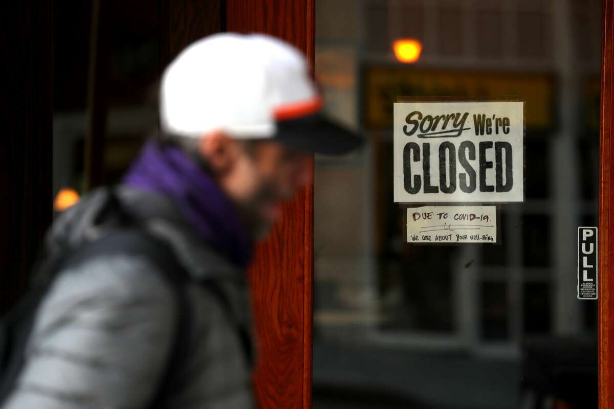 FILE - A pedestrian walks by a closed sign on the door of a restaurant on March 17, 2020 in San Francisco. After a tumultuous year, the exact number of restaurant closures in San Francisco is still uncertain. But there are some key figures to know.