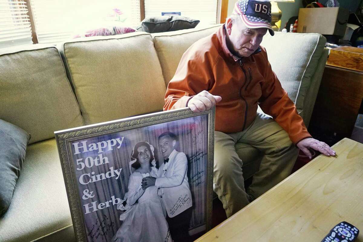 Herbert Sodher sits in his living room on Tuesday, March 17, 2020, in Saratoga Springs, N.Y. next to a large photo of he and his wife Cynthia on their wedding day given to them on their 50th wedding anniversary. Cynthia is an Alzheimer's patient in hospice in Saratoga Springs and Herbert is unable to visit her because of new rules at the hospice that limit visitations to cases only when the patient is close to death. (Paul Buckowski/Times Union)