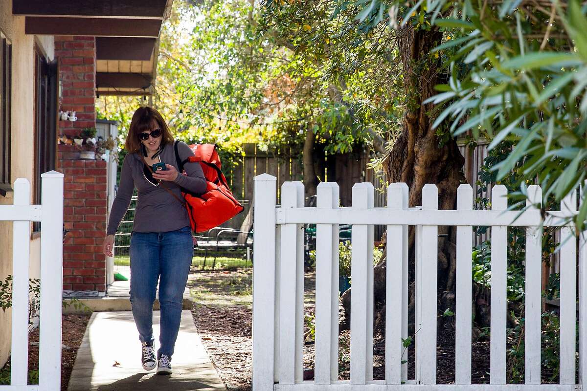 Grocery delivery shopper Courtney Fox of Newark delivers Instacart orders to various homes in Palo Alto, Calif. Tuesday, March 17, 2020. As a shopper for Instacart, Fox finds herself on the front lines of keeping homebound Bay Area people supplied with food and essentials during the threat of the Coronavirus and shelter-in-place order was given to six Bay Area counties on Monday, March 16.