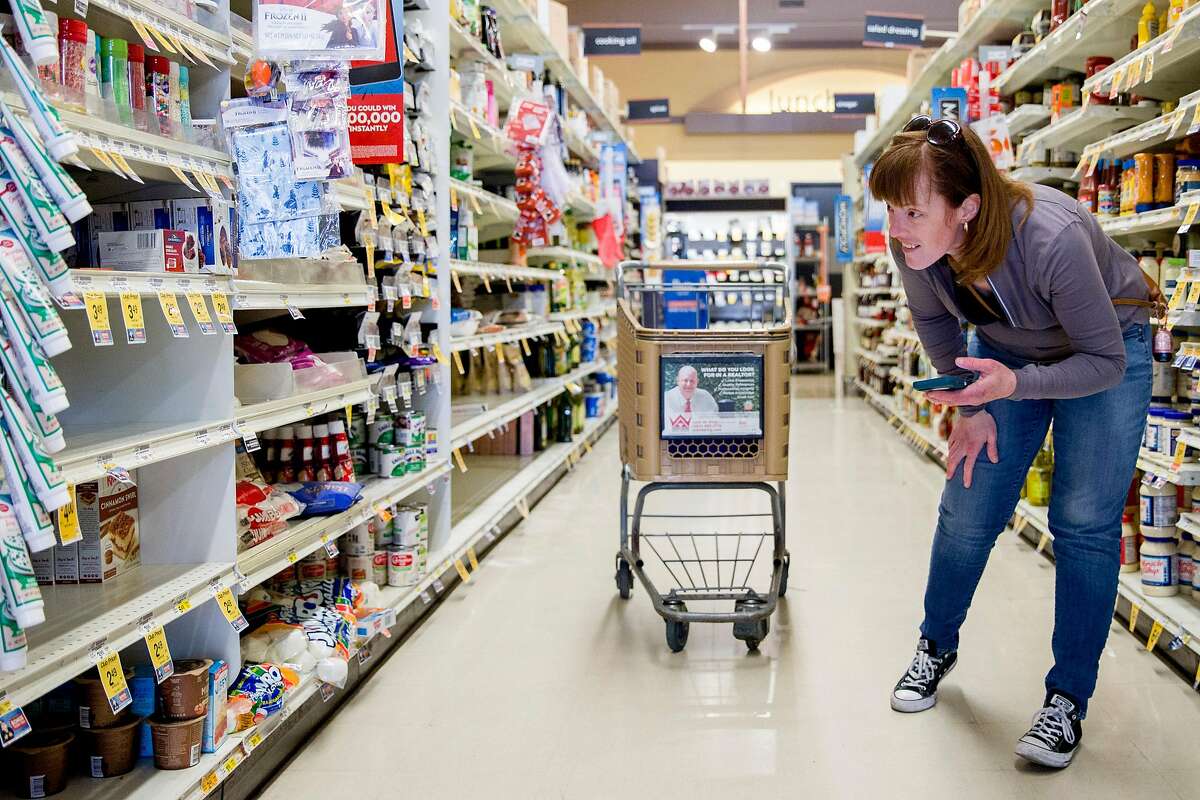 Grocery delivery shopper Courtney Fox of Newark searches for items for three separate Instacart orders at Safeway in Palo Alto, Calif. Tuesday, March 17, 2020. As a shopper for Instacart, Courtney Fox finds herself on the front lines of keeping homebound Bay Area people supplied with food and essentials during the threat of the Coronavirus and shelter-in-place order was given to six Bay Area counties on Monday, March 16.