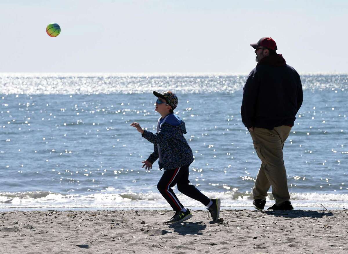 Logan McCormick (left), 7, of Enfield plays ball with his father, Mike, at Hammonasset Beach State Park's West Beach in Madison on March 15, 2020.