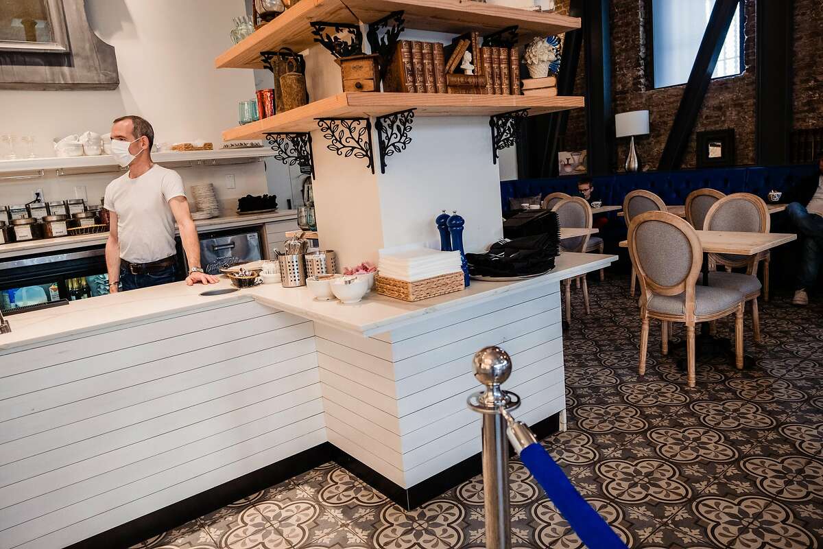 Danel De Betenlu owner of Maison Danel a cafe on Polk Street that just opened two weeks ago waits for take out orders behind the counter in San Francisco, Calif. onTuesday, March 17, 2020.