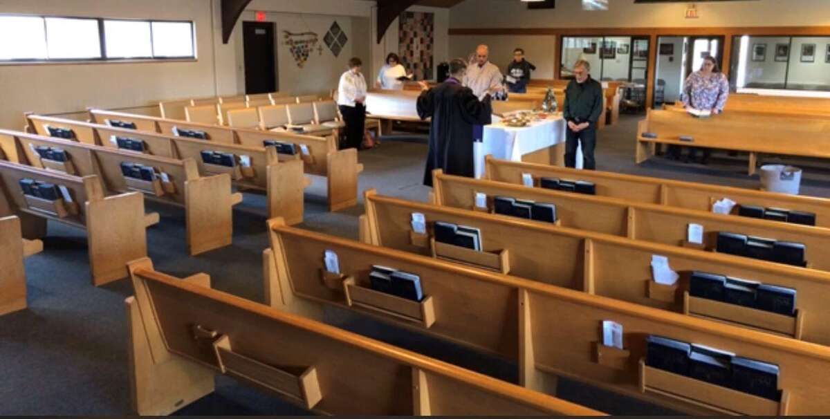 Places of worship are offering remote worship services, above, as streamed via Facebook Live, in light of the novel coronavirus outbreak. Above, a handful of parishioners join their pastor at worship March 15 at the New Milford United Methodist Church.