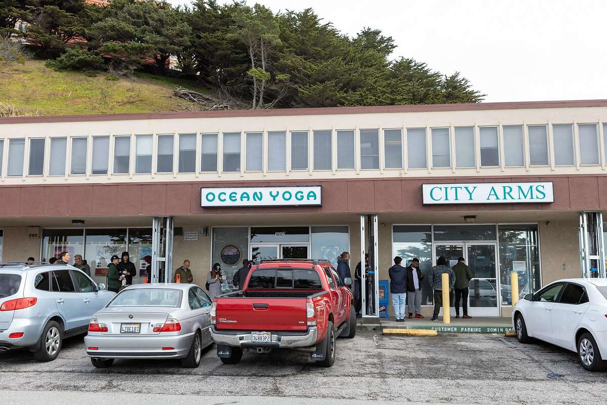 People wait in line to enter City Arms on Tuesday, March 17, 2020, in Pacifica, Calif.