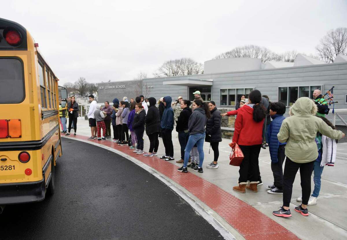 Students and parents line up to receive bagged lunches at New Lebanon School in the Byram section of Greenwich, Conn. Tuesday, March 17, 2020. The school district is providing breakfast and lunch Monday through Friday to more than 1,000 students while schools are closed.