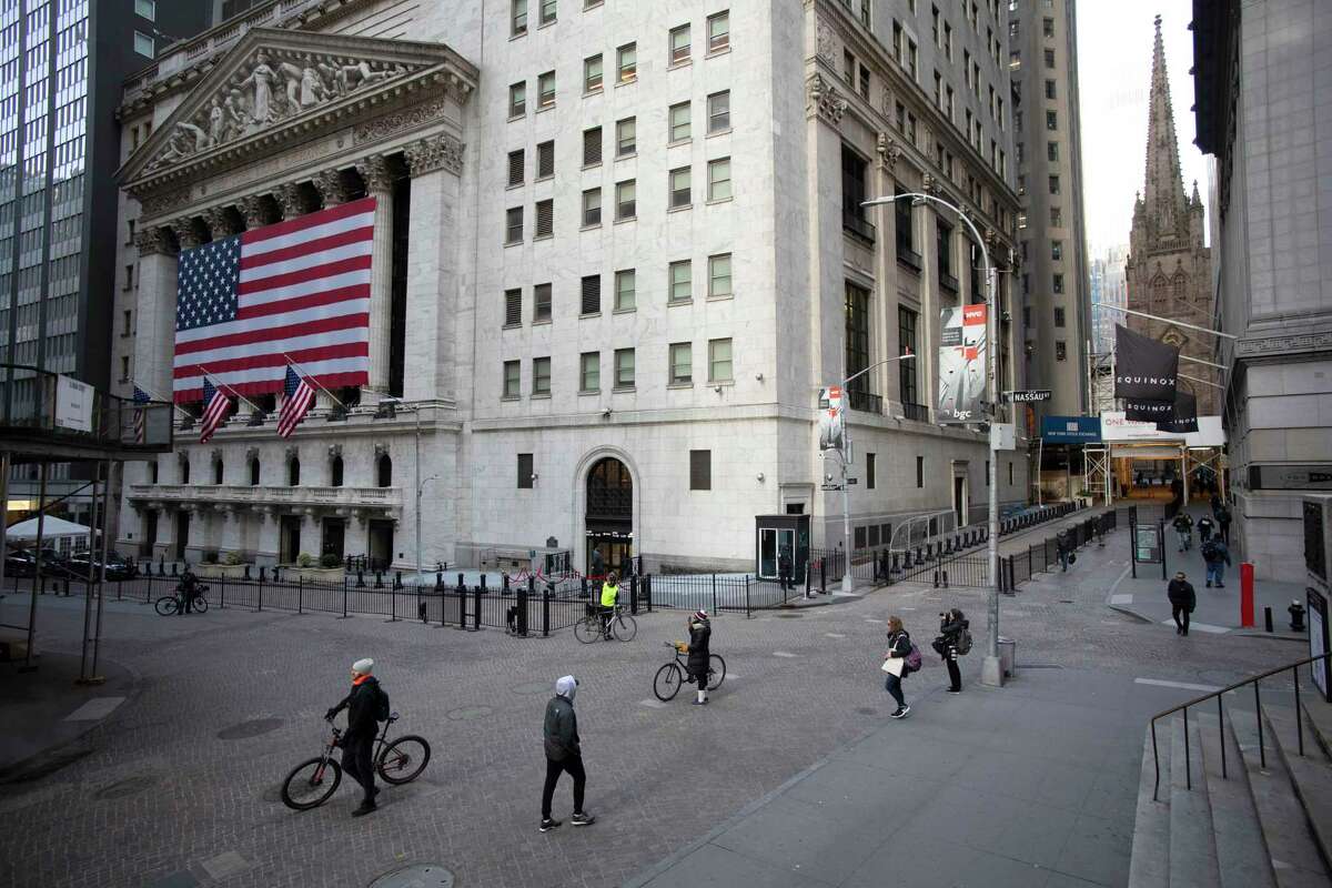 A few people walk on Wall Street in front of the New York Stock Exchange on Wednesday.